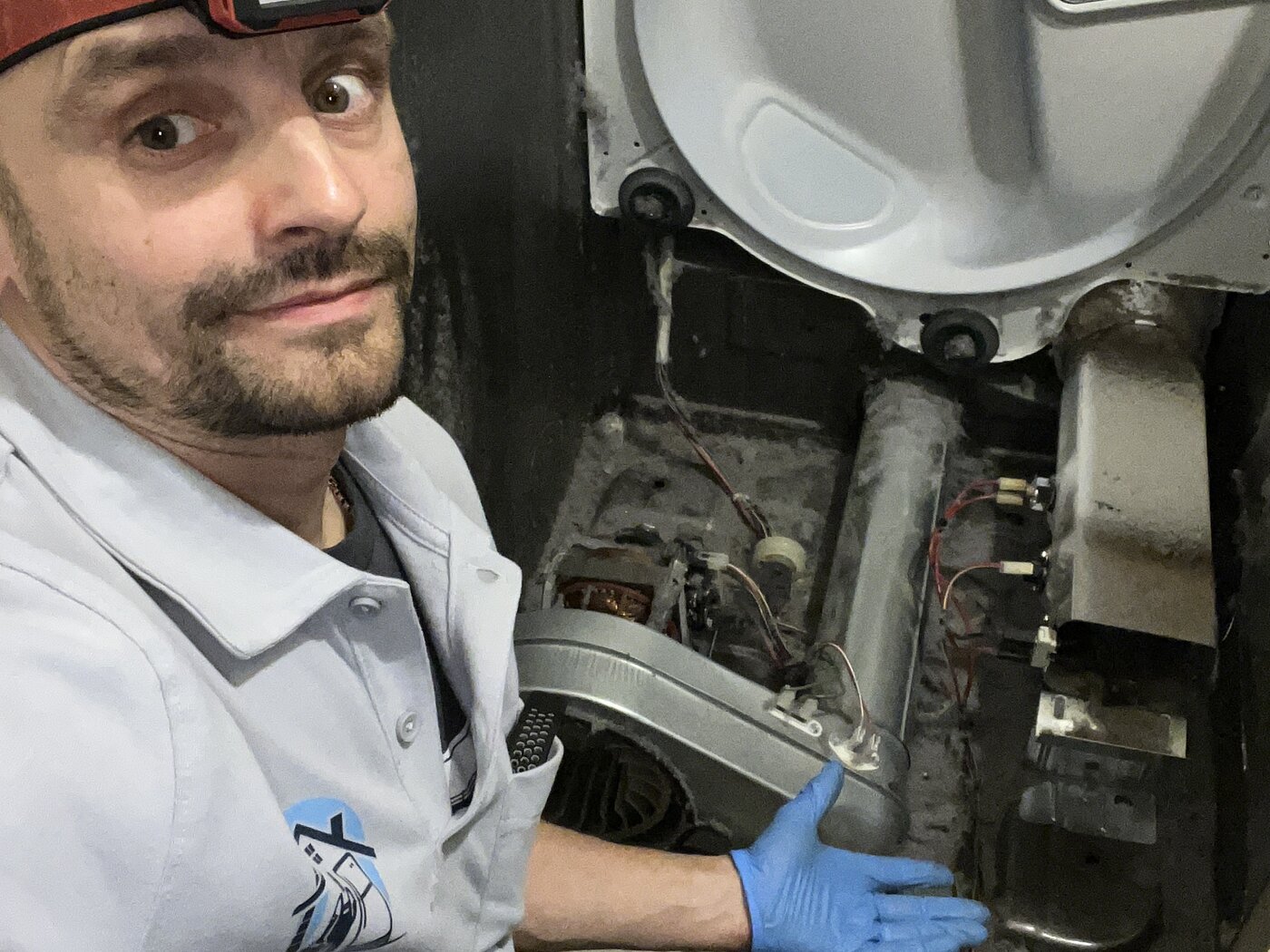 Konstantin in branded polo next to a dryer with drum and heating element exposed