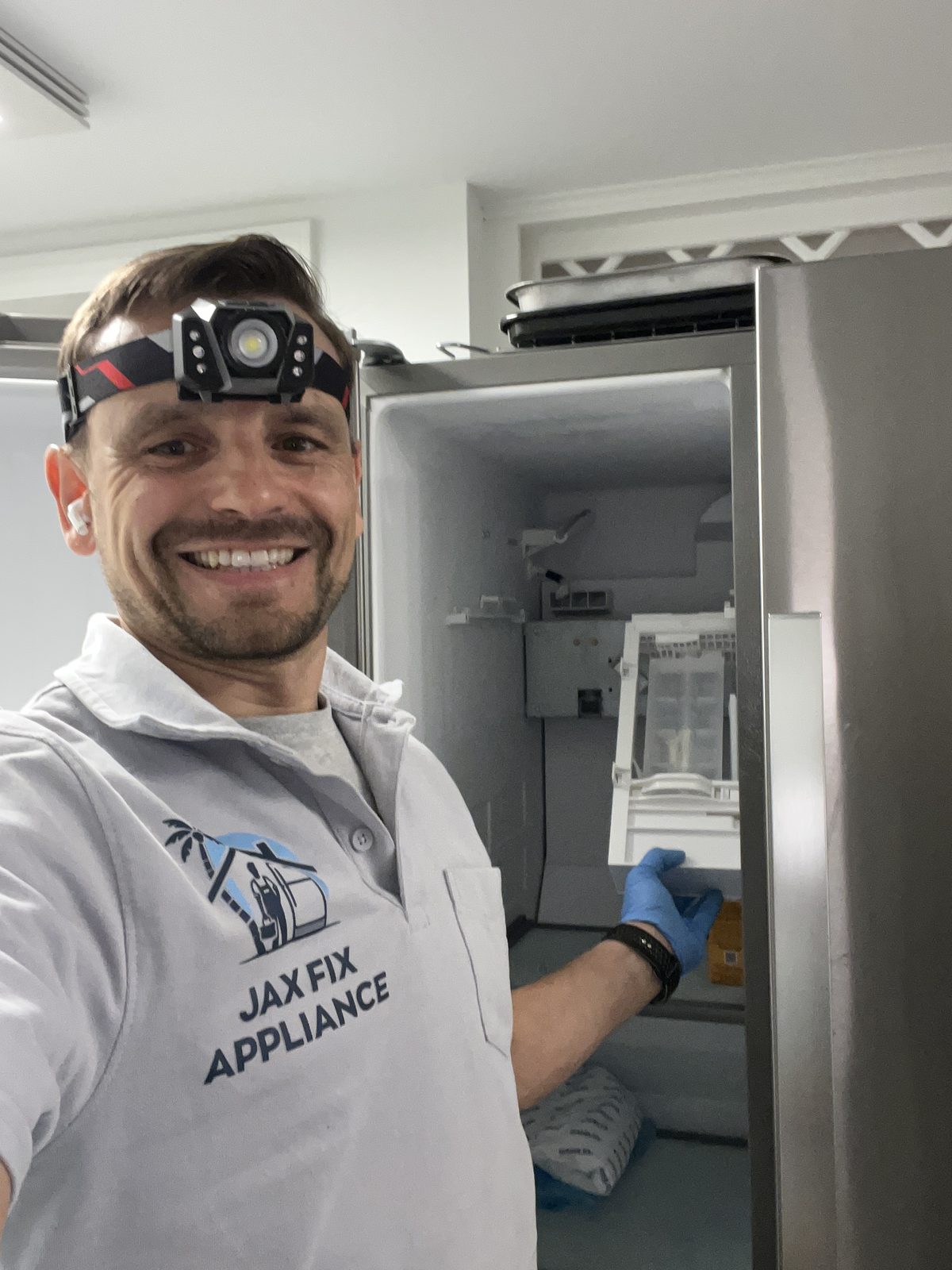 Konstantin at a refrigerator ice maker compartment after a completed repair