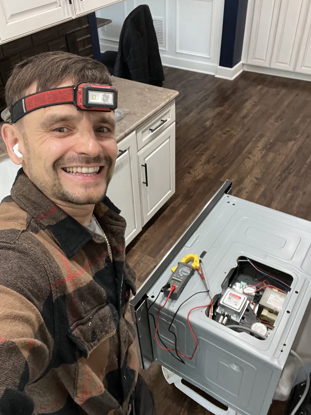 Konstantin using a multimeter to diagnose an electric oven