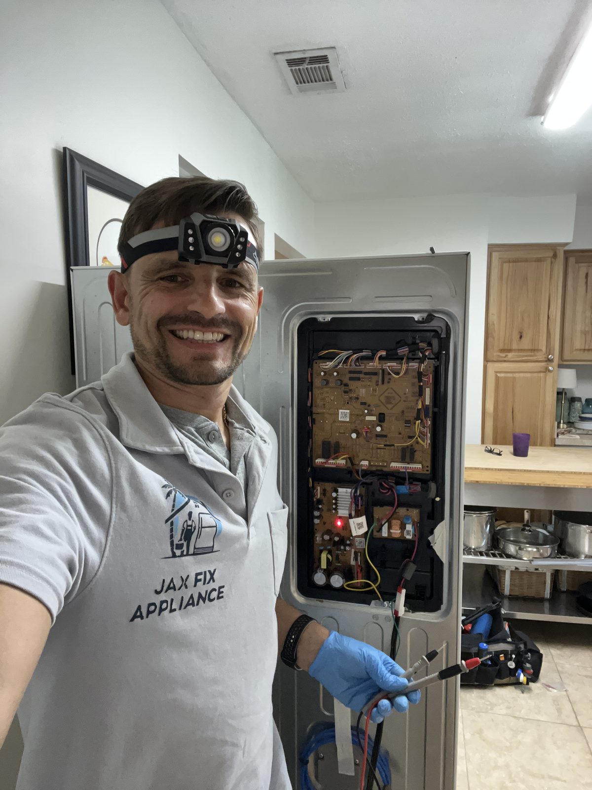 Konstantin diagnosing a refrigerator control board with the rear panel open