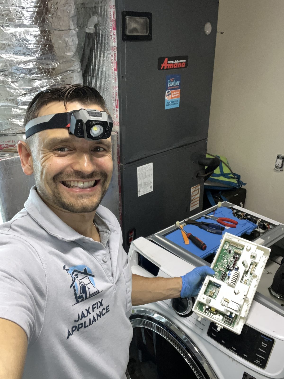 Konstantin holding a washer control board during an electronic repair