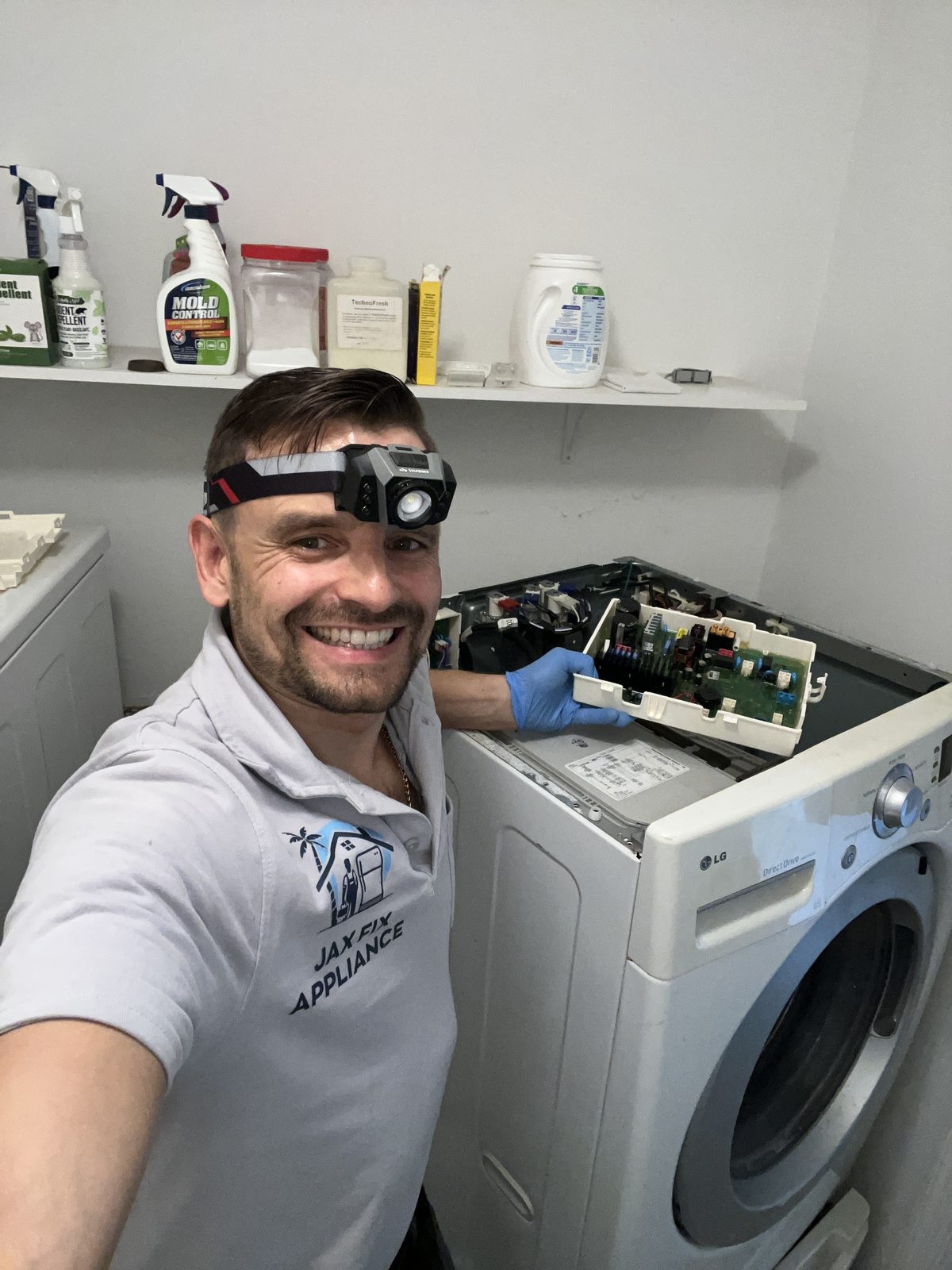 Konstantin at an LG front-load washer with the top panel off and control board out