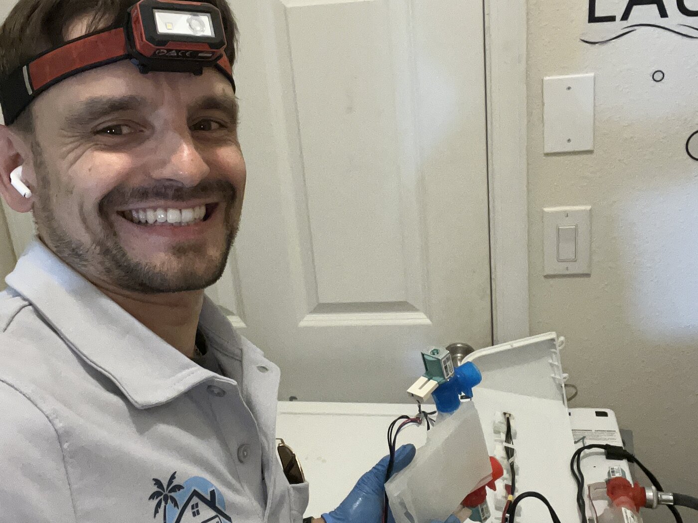 Konstantin holding a washer control panel with inlet valves exposed