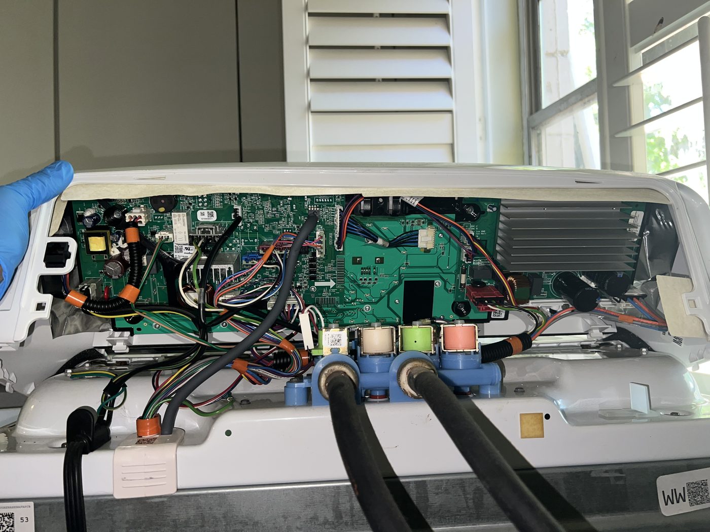 Washing machine back panel exposed with the main control board